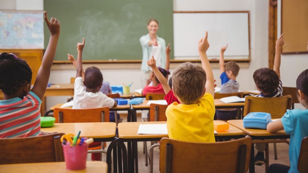 students raising their hands at school | Reading and Math Scores for middle school drop to lowest levels| Featured