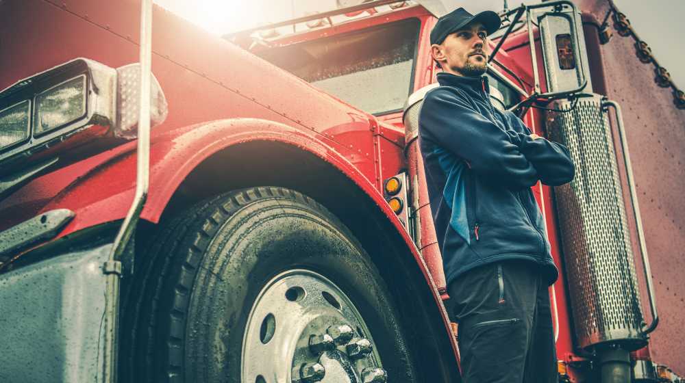 Semi Truck Driver in Front of His Awesome Machine | Walmart Wants Truck Drivers Real Bad, Offers $110K in Salary | featured