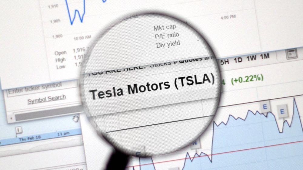 Tesla Motors stock market ticker with charts under magnifying glass-Tesla Enters S&P 500-ss-featured
