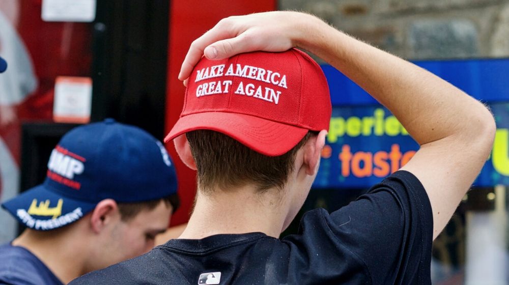 Two young men wearing Make America Great Again | Anonymous Group Releases Pigeons in MAGA Hats During Democratic Debate | Featured