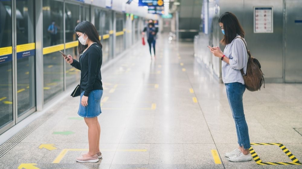 Two Young Asian Woman Wearing Protective Face Mask | Experts Call for Federal Intervention as Top Doc Warns COVID-19 Cases Could Top 100K Per Day | Featured