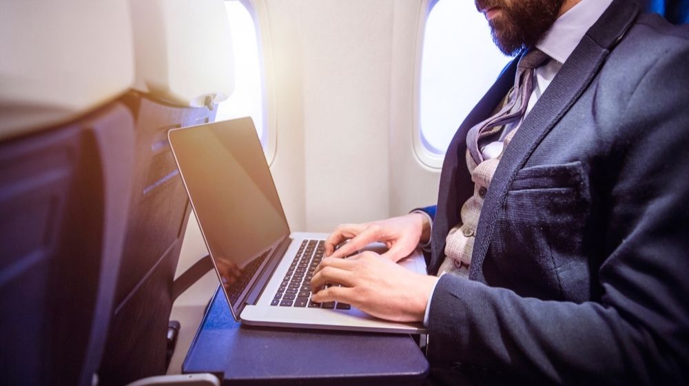 Unrecognizable Young Businessman with Notebook Sitting Inside an Airplane | Laptop Battery Catches Fire on an Alaska Airlines Boeing 737 | Featured