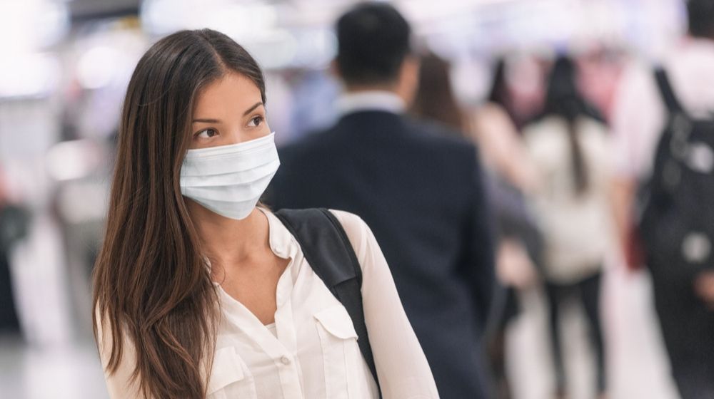 Asian woman traveling wearing a mask | Laredo, Texas Requires Residents to Wear Masks or Pay $1,000 Fine | Featured