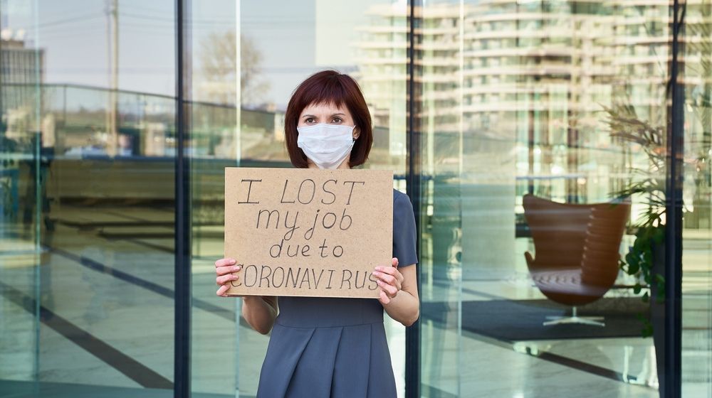 woman with mask holding i lost my job sign | U.S. Economy Lost 701,000 Jobs as Coronavirus Rages | Featured