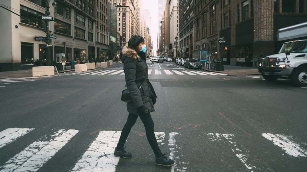 woman crossing a street | Study Suggests Millions of New Yorkers Infected | Featured