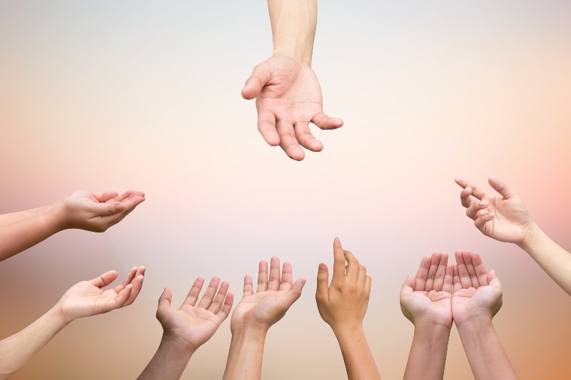 close up helping hand and hands praying for healing and support concept | Does Society Want Empowered Victims?