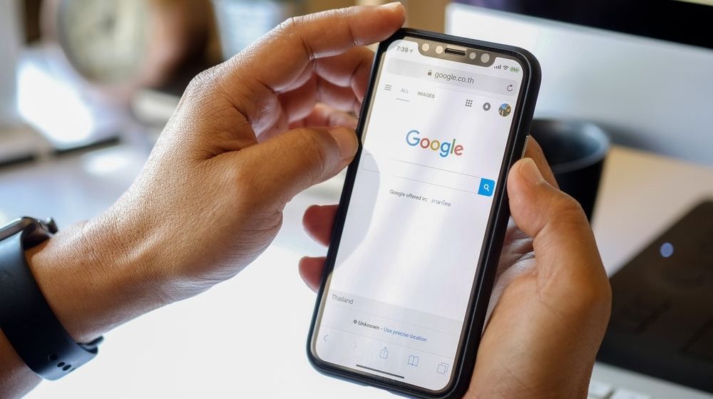 Close Up of a Man's Hand Hold iPhone X | Trending Google Searches on Election Day: “Liquor Store Near Me,” “Fries Near Me” | Featured