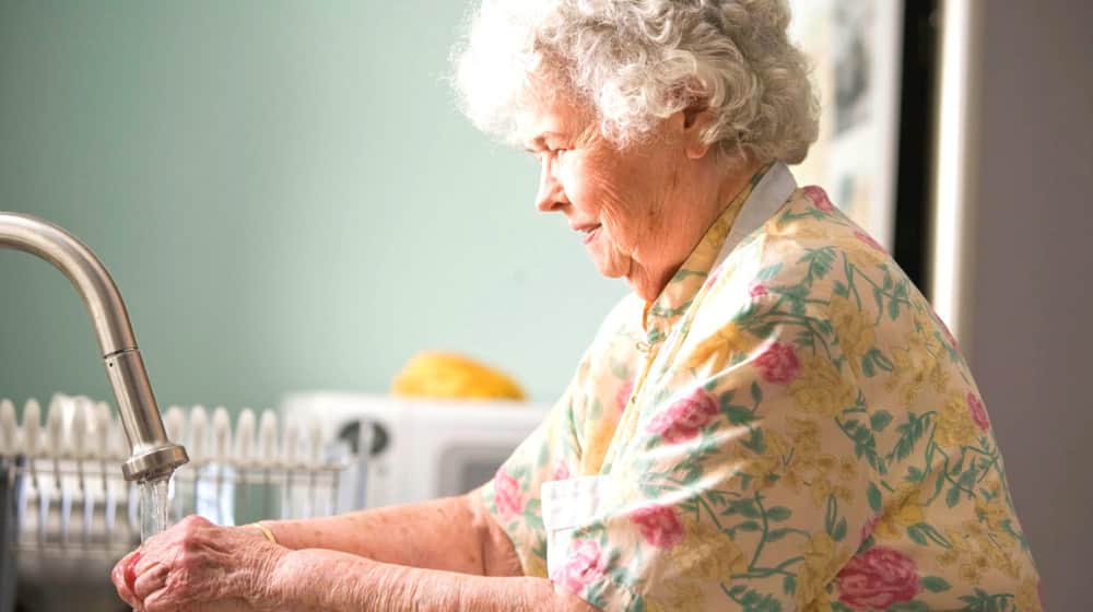 Old woman washing glass | WebMD Health Services Launches New Custom Health Plans for Senior Members | Featured 
