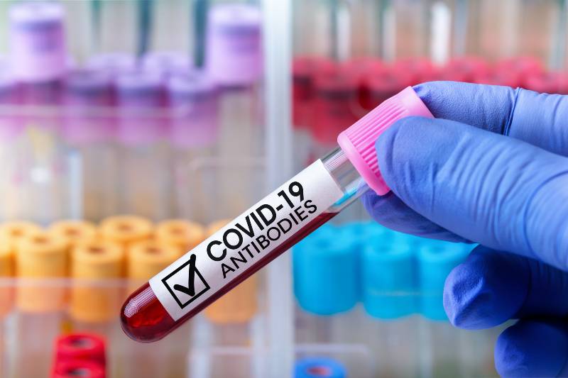 epidemiologist with an antibody blood tube from a cured Covid-19 patient | Americans With COVID Antibodies Increased From 34% to 58%