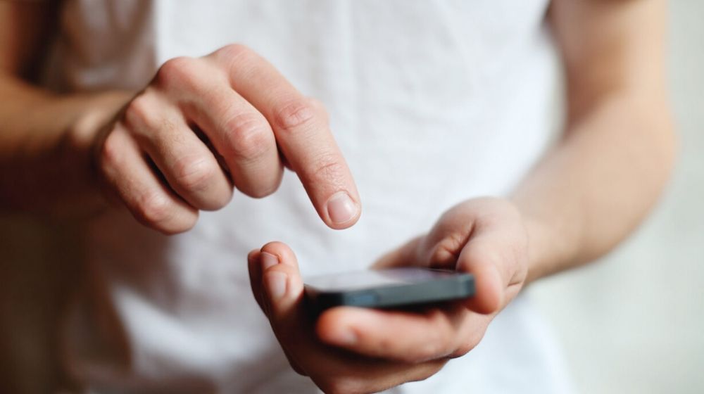 man holding a smartphone | Mobile Apps Help Those Who Are Unemployed Amid Coronavirus Pandemic | Featured