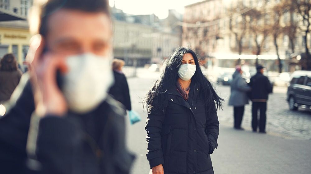 man and woman in black wearing face mask | WHO Says Rushing to Ease Coronavirus Restrictions May Cause Resurgence | Featured