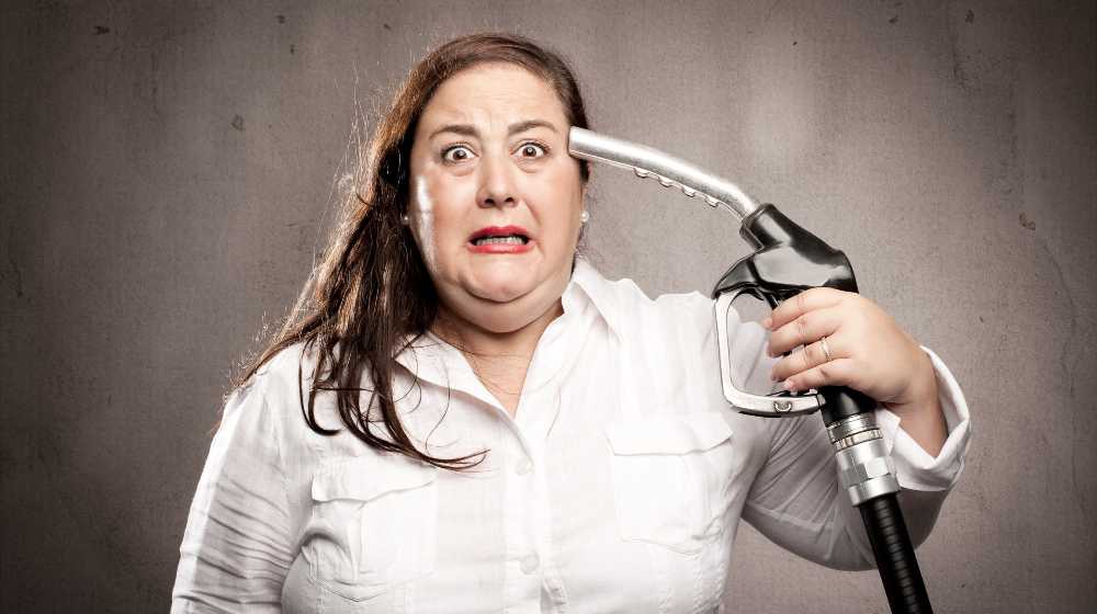 woman shooting herself with a fuel pump nozzle | Gasoline Prices To Average More Than $4 Per Gallon Next Year | featured