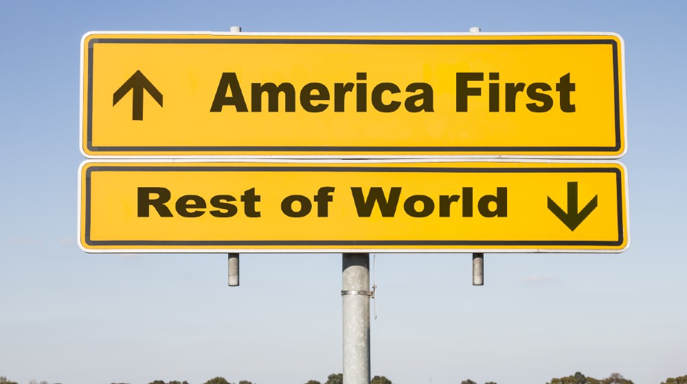 yellow traffic and direction sign with two arrows showing up and down and the words America first and Rest of world-America First for COVID-19 vaccines-ss-featured