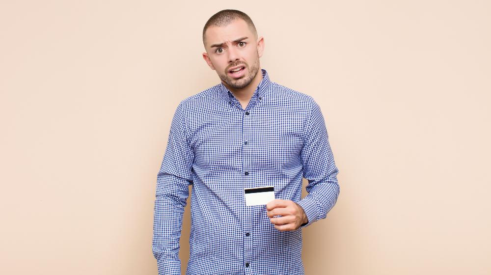 young handsome man feeling puzzled and confused, with a dumb | Avoiding Dumb Debt at All Costs | featured